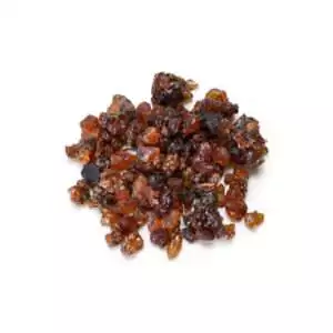 Small pile of glossy reddish-brown and dark amber myrrh resin tears of varied size on a plain white background.