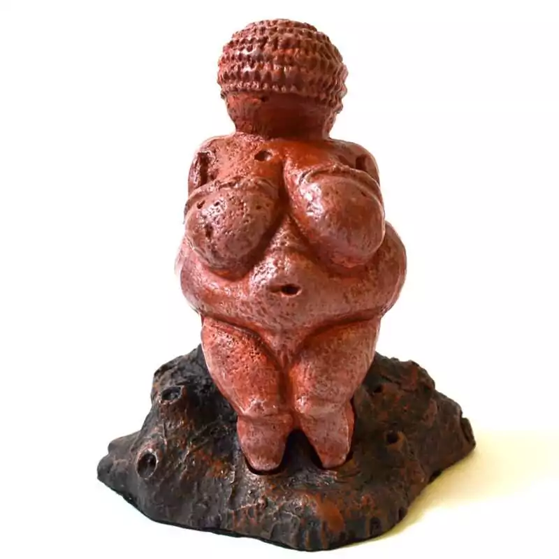 4quot-Venus-of-Willendorf-SV562 Venus of Willendorf replica statue: a red-brown figure with a banded head, rounded body, and arms across the breasts, standing on a dark rock-textured base.
