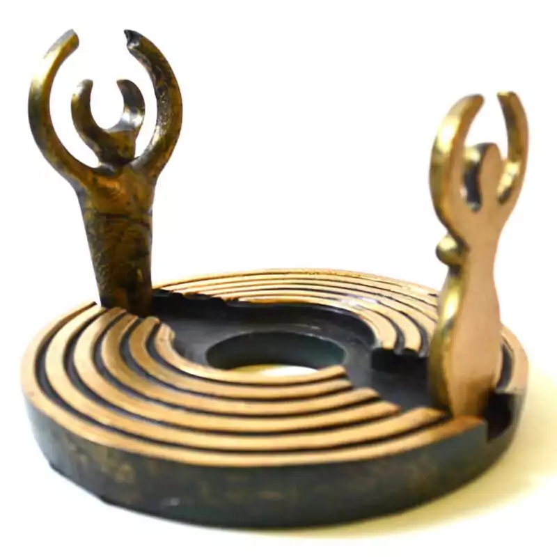5-14quot-Dearinth-Mini-Altar-SD555 Dearinth Mini Altar: a round bronze-toned labyrinth base of concentric raised ridges with two upright cut-out figures, the Goddess and the God, arms raised in crescents, around an open center.