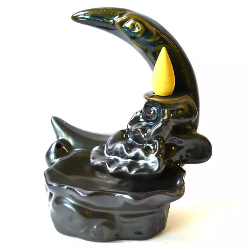 5quot-Crescent-Moon-backflow-incense-burner-IBF3546 Black glazed ceramic crescent moon backflow incense burner with a sculpted eye, a yellow cone in the cone dish, and sculpted clouds above a wavy basin, on white
