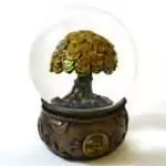 Money tree water globe: a clear sphere with glitter around a gold-toned tree of overlapping coins, on a bronze-toned base wrapped in gold rope with ingots and a coin medallion.