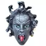 Medusa head statue in stone-gray resin with turquoise eyes, an open mouth showing fangs and a red tongue, and coiling snakes rising from her hair and crown.
