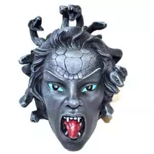 Medusa head statue in stone-gray resin with turquoise eyes, an open mouth showing fangs and a red tongue, and coiling snakes rising from her hair and crown.