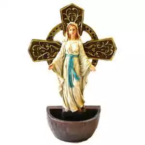 Lady of Grace holy water font: Mary in a white hooded robe with a turquoise sash and open arms before a gold-toned ringed cross, above a bronze-toned half-round basin.