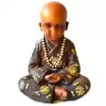 Seated monk statue with a shaved head and downcast eyes, hands resting in his lap, in a brown robe with gold-toned roundels and a long strand of gold-toned prayer beads.