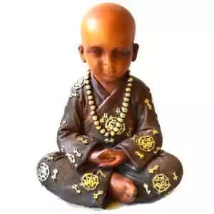 Seated monk statue with a shaved head and downcast eyes, hands resting in his lap, in a brown robe with gold-toned roundels and a long strand of gold-toned prayer beads.