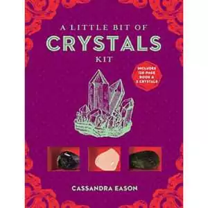 A Little Bit of Crystals Kit box by Cassandra Eason with a purple cover, a mint-green quartz cluster drawing and three tumbled stones shown in red compartments
