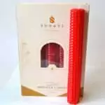 Vivid red 8 inch hand-rolled honeycomb beeswax candle with a white wick standing in front of its cream box marked Natural Beeswax Hand Roll Beeswax Candle, Pack of 5