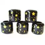 Set of five black ceramic Stars and Moon candle holders stacked in a pyramid, scattered with gold stars, crescent moons and dots