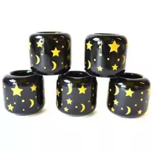 Set of five black ceramic Stars and Moon candle holders stacked in a pyramid, scattered with gold stars, crescent moons and dots
